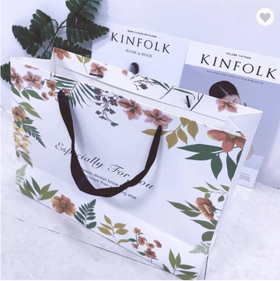 Un buen precio. Bolsa de papel laminada de goma de cartón envasado de papel de arte bolsas de regalo de lujo con flor en línea